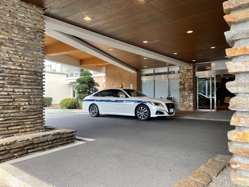 Fujisaki Taxi Crown sedan parked at the entrance of Narashino Country Club in Chiba, the official venue of the ZOZO Championship.