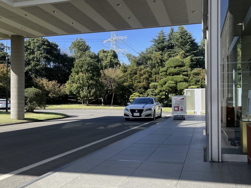 A private taxi Crown sedan waiting at the main entrance of Tokyo Yomiuri Country Club, a prestigious JT Cup tournament course.