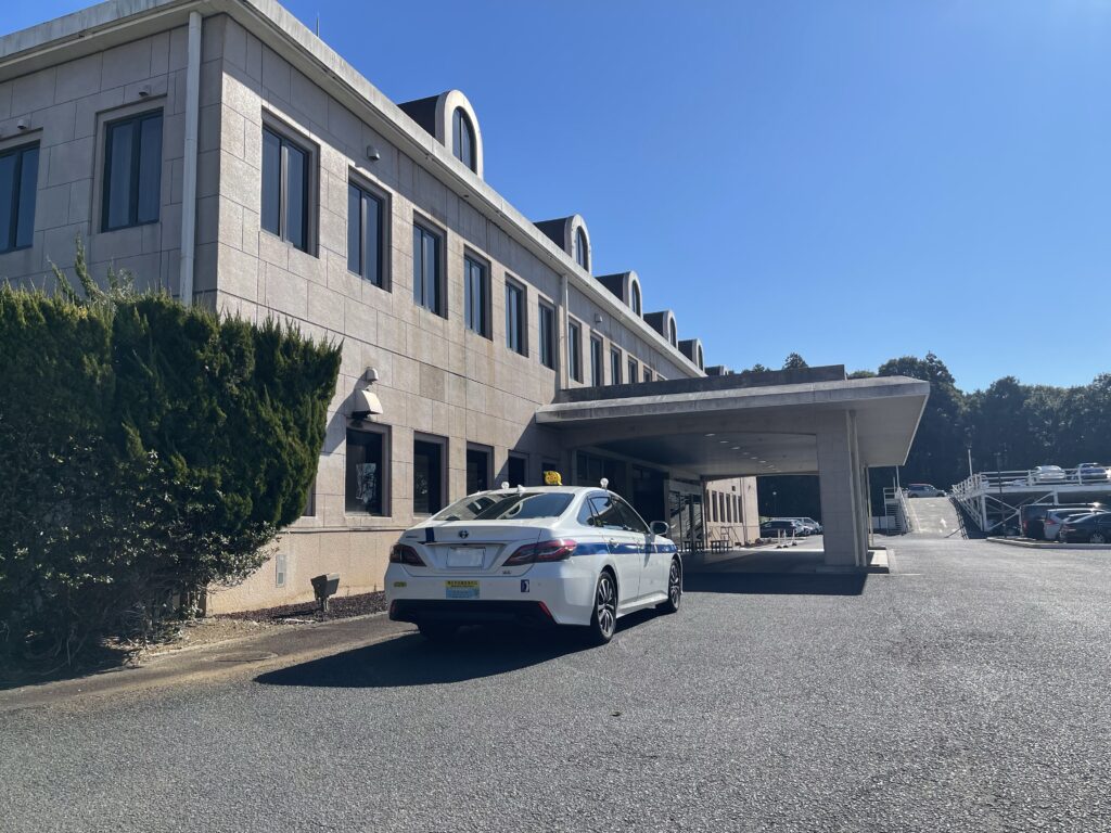 成田の森カントリークラブのクラブハウス前に停車するFUJISAKI TAXIクラウン個人タクシー