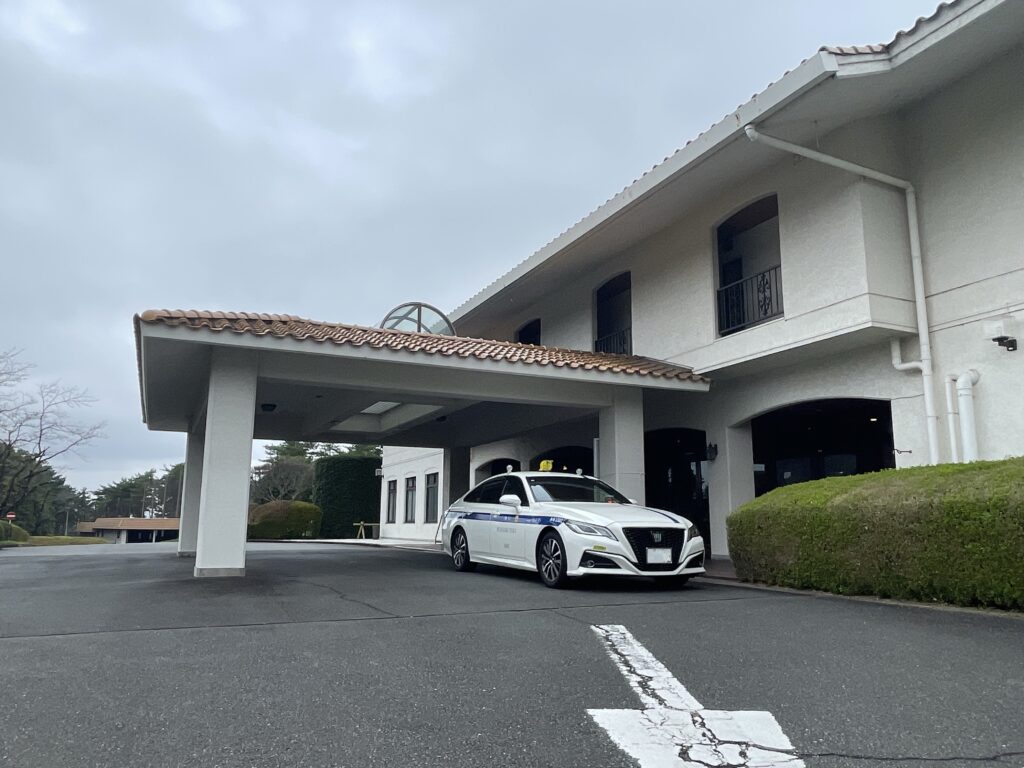 こだまゴルフクラブでの個人タクシー送迎。白いクラウンがクラブハウス前に停車している様子。