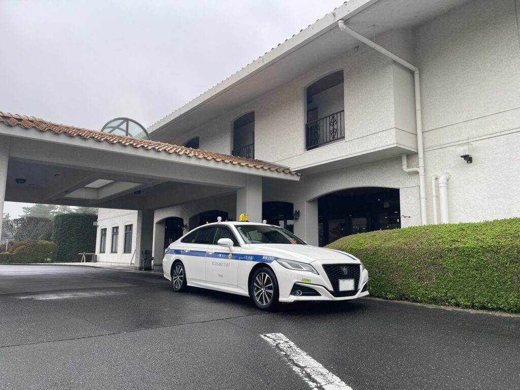 こだまゴルフクラブのエントランス前に停車するFUJISAKI TAXIクラウン個人タクシー。ハイヤー出身ドライバーによるゴルフ場送迎。
